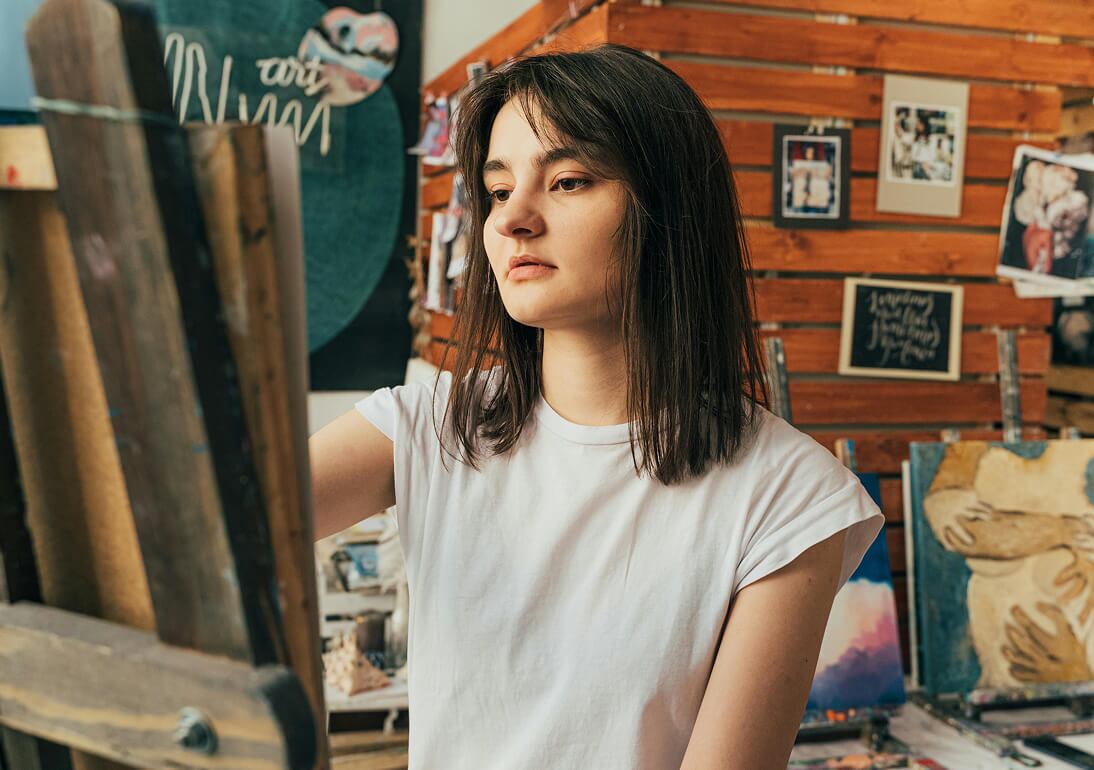 young woman working on an artwork in progress on an easel