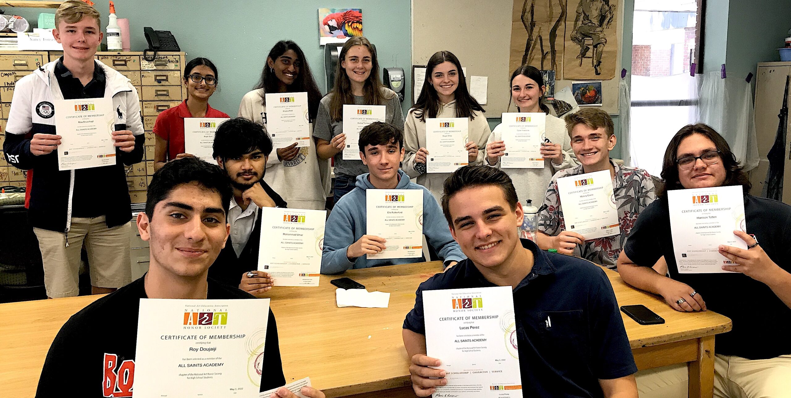 Photo of students holding up NAHS certificates of membership