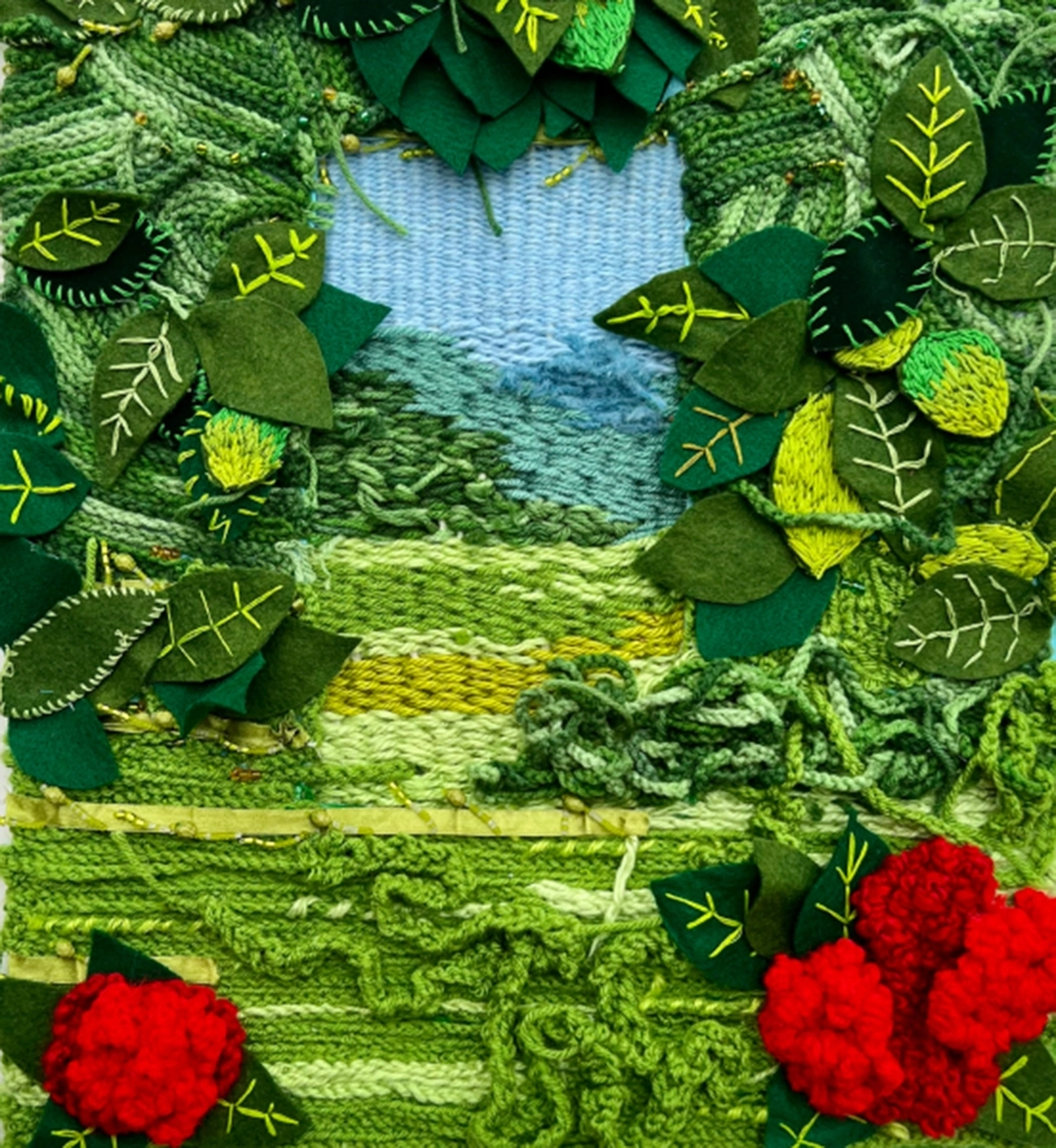 multimedia fiber and fabric artwork depicting leaves and flowers on a grassy-green backdrop